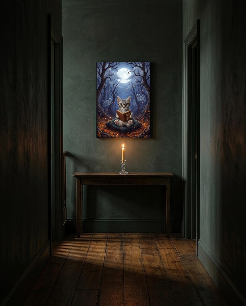 The kitten and ghosts ghost reading print framed alone in a dim charcoal-green hallway above a console with a single lit candle