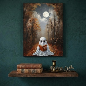 The autumn forest ghost reading print framed on a deep teal wall above a narrow shelf with antique books and a brass candlestick