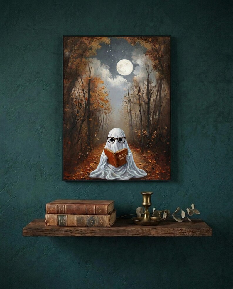 The autumn forest ghost reading print framed on a deep teal wall above a narrow shelf with antique books and a brass candlestick