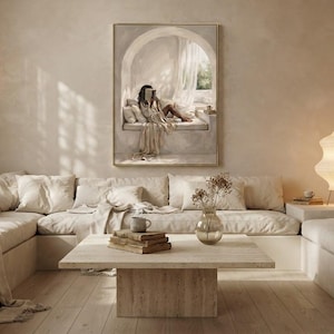 Wide living room view showing the Black woman reading nook wall art centered above a low sofa, gold frame, no mat.