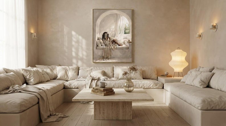 Wide living room view showing the Black woman reading nook wall art centered above a low sofa, gold frame, no mat.