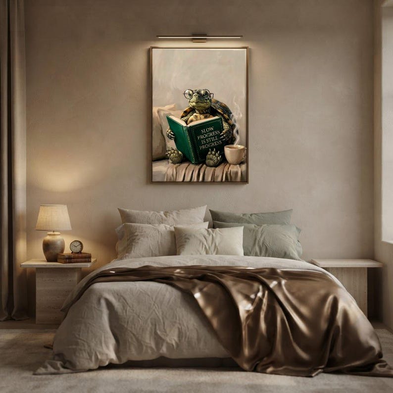 Tortoise reading art print framed on a textured plaster bedroom wall above linen bedding in soft morning light