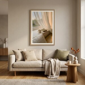 Window seat wall art print hanging above sofa, book and coffee on ledge with sheer curtains, Japandi living room decor, beige neutral sofa with pillows and knitted throw, slow living interior style, minimalist Scandinavian furniture, digital printable wall art