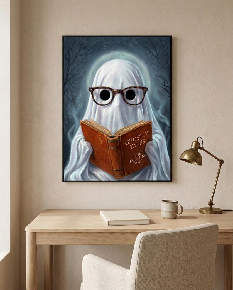 The ghost reading print above a pale oak desk with a stoneware mug, a brass lamp and a notebook