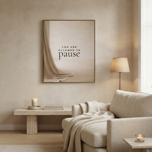You Are Allowed to Pause styled in a calm neutral living room, hung in a thin gold frame with no mat. neutral printable wall art, minimalist home decor, Japandi style, calm living room decor, slow living digital download.