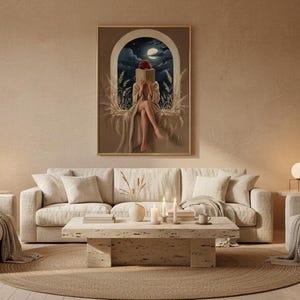 Wide view of a neutral living room with the moonlit reading print framed above a low linen sofa in soft daylight