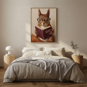 Painterly print of a red squirrel in round tortoiseshell glasses reading a wine-red book framed on a textured plaster bedroom wall above linen bedding in soft morning light