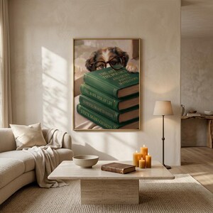 Dog peeking over books wall art framed on a warm plaster wall in a calm light-filled living room with a cream linen sofa
