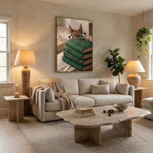 Squirrel peeking over books wall art framed on a warm plaster wall in a calm light-filled living room with a cream linen sofa