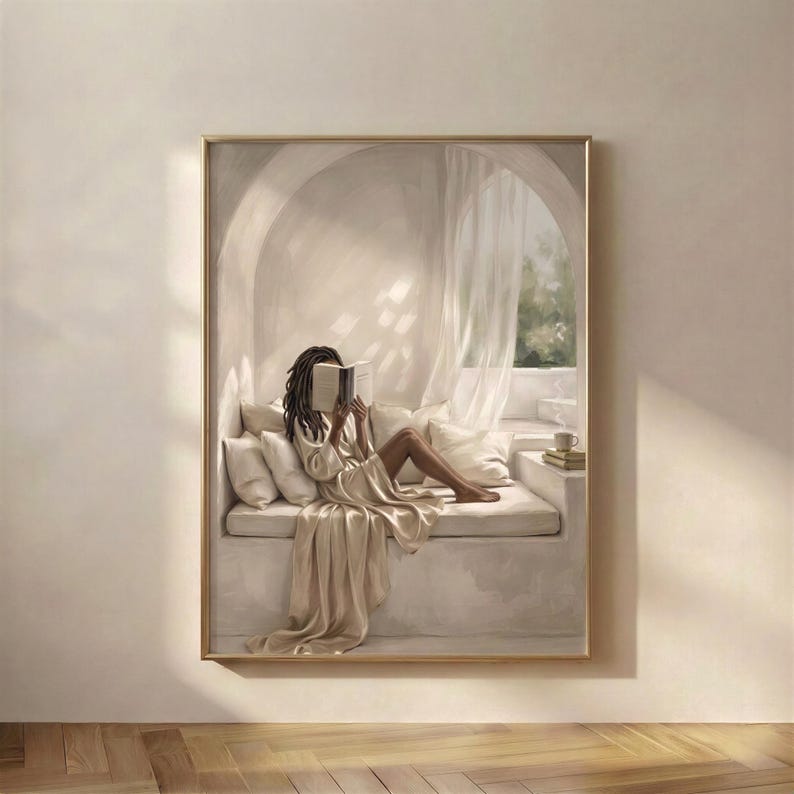 Black woman reading in a quiet arched reading nook, neutral wall art print hung in a cozy reading corner with soft plaster walls, draped linen, and warm beige daylight, thin gold frame, no mat.