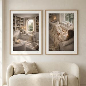 A pair of neutral wall art prints in light oak frames with wide white mats, hung above a cream boucle sofa with linen cushions and a jute rug. Minimalist wall art of a library nook and a quiet reader.