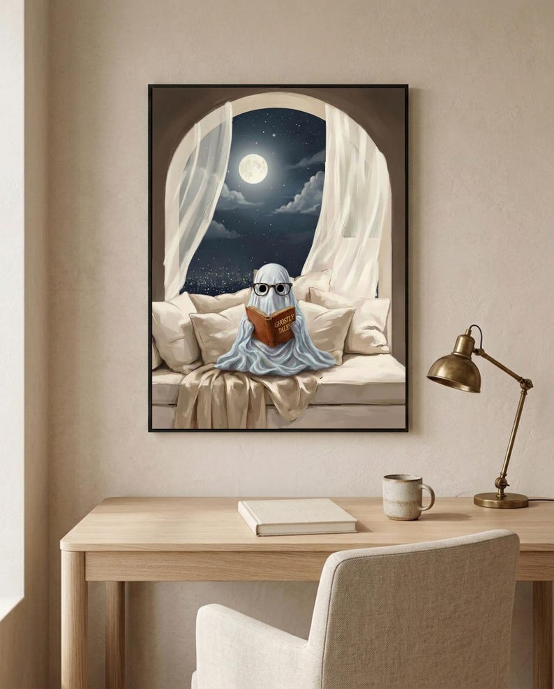 The moonlit bed ghost reading print framed above a pale oak desk with a stoneware mug and a brass lamp