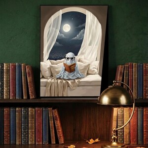 The moonlit bed ghost reading print framed and leaning on a dark wood library shelf against a deep green wall