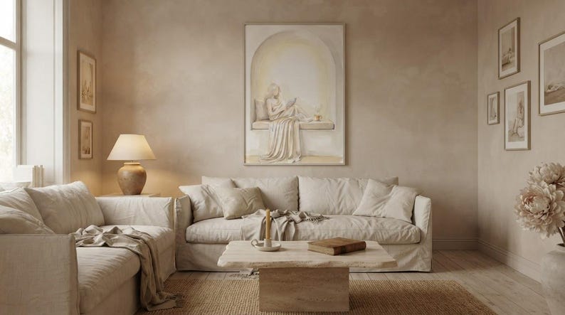Wide living room view showing the woman reading nook wall art centered above a low sofa, gold frame, no mat.