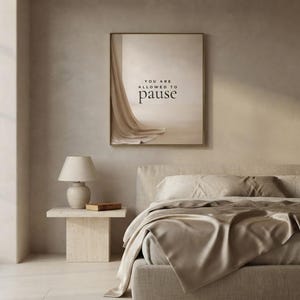 You Are Allowed to Pause styled in a quiet neutral bedroom, hung in a thin gold frame with no mat. neutral printable wall art, minimalist home decor, Japandi style, calm living room decor, slow living digital download.