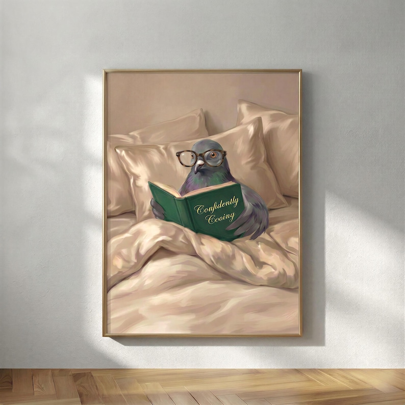 The framed pigeon reading print in a thin gold frame on a warm plaster wall above a wooden floor