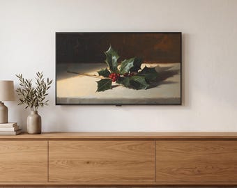 May include: A rectangular wall-mounted television displaying a still life painting of a sprig of green holly leaves with bright red berries resting on a light-colored surface against a dark brown background, positioned above a long wooden media console.