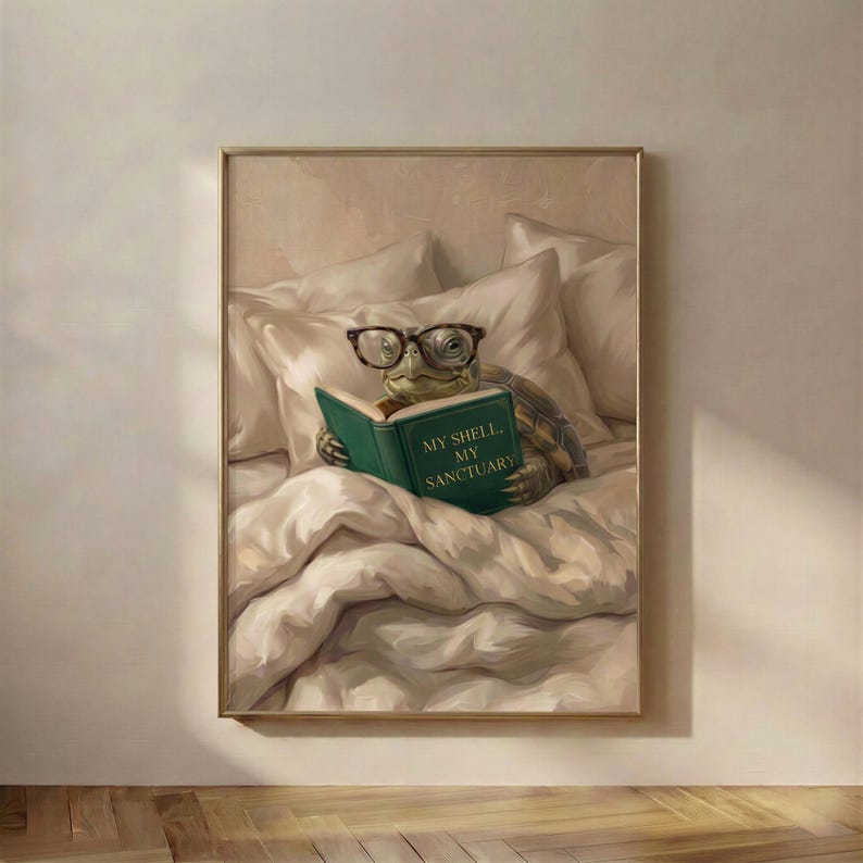 The framed tortoise reading print in a thin gold frame on a warm plaster wall above a wooden floor