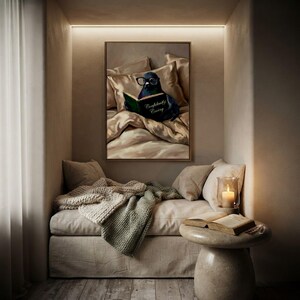 The framed pigeon print in a cushioned alcove reading nook with a knitted throw, a lit candle and an open book on a round stone side table