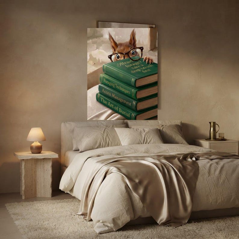 Squirrel peeking over books art print framed on a textured plaster bedroom wall above linen bedding in soft morning light