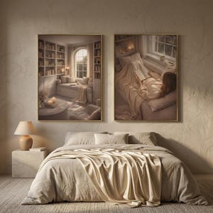 Bedroom wall art: two gold framed reading nook prints above a bed made up in linen with a cream silk throw, beside a ceramic lamp on a stone nightstand. Minimalist wall art in warm neutral tones.