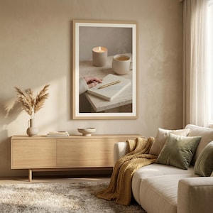 Evening journal ritual wall art printable above wooden media console with white sofa and pampas grass, neutral beige living room mockup