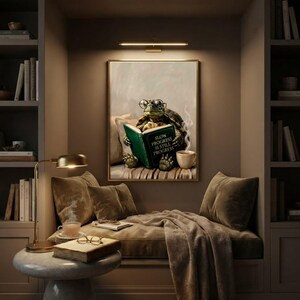 Framed tortoise reading print in a quiet reading corner beside a low sofa and a small lamp