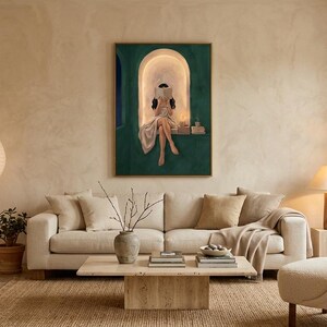Emerald green reading nook art print above a cream linen sofa in an airy plaster living room, with a boucle armchair, a travertine coffee table, paper lanterns and potted plants.