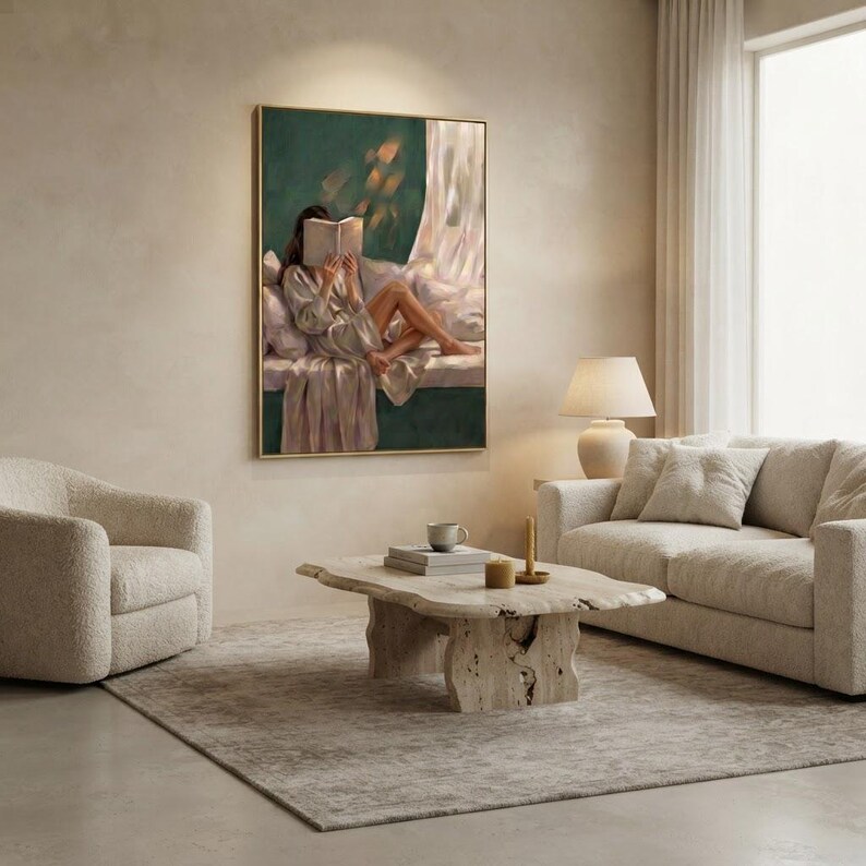 Jewel tone emerald wall art hanging on a warm plaster wall between a boucle armchair and sofa, styled with a travertine coffee table, candles and books.
