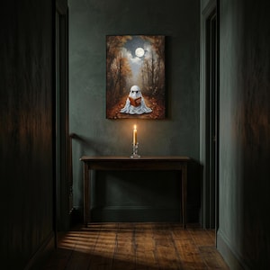 The autumn forest ghost reading print framed alone in a dim charcoal-green hallway above a console with a single lit candle