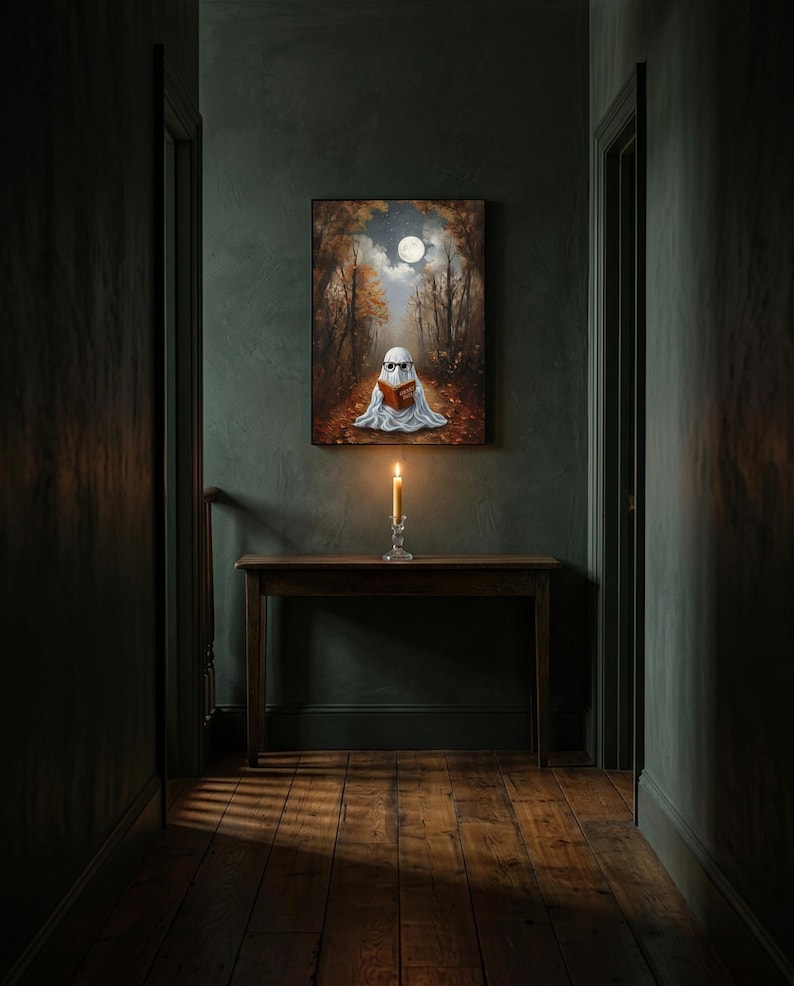 The autumn forest ghost reading print framed alone in a dim charcoal-green hallway above a console with a single lit candle