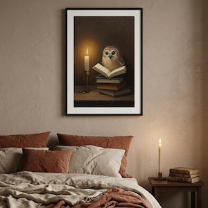 Framed tawny owl reading print above a bed with terracotta and cream linen