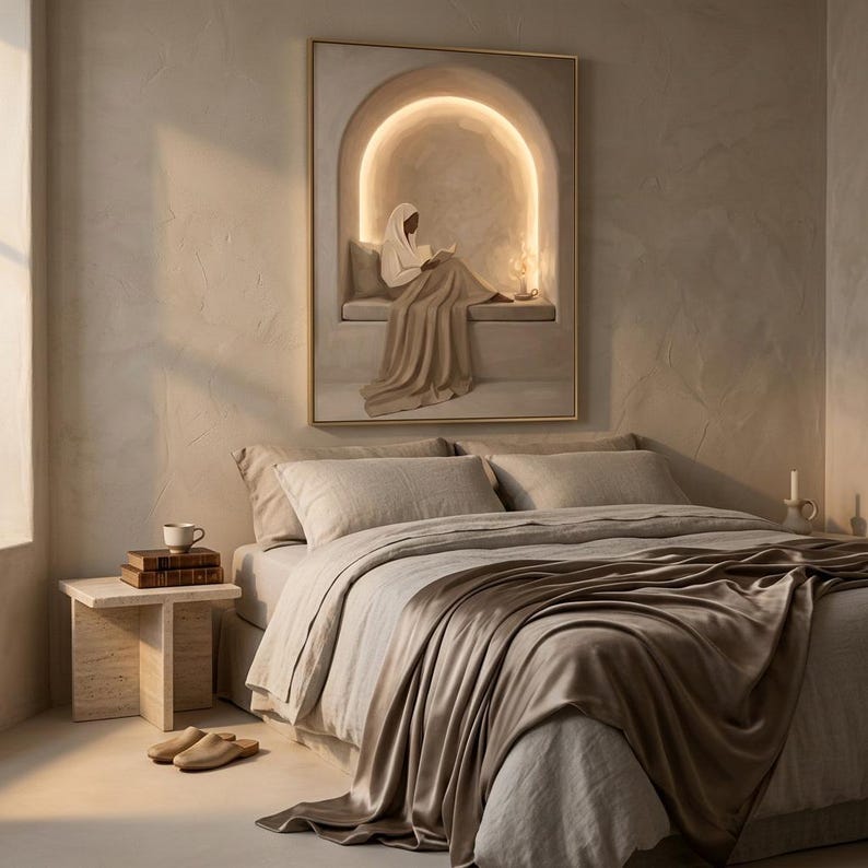 May include: A rectangular wall art print featuring a person in a head covering sitting in a glowing arched alcove while reading a book. The artwork uses neutral beige and cream tones, depicting a draped figure on a ledge with soft lighting.