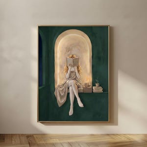 Emerald green reading nook art print of a blonde woman reading by candlelight, in a thin gold frame on a plain plaster wall.