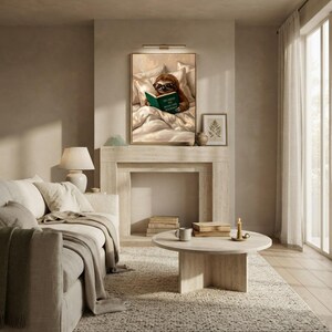 The sloth reading print framed above a stone fireplace in a bright living room with a linen sofa, a round travertine table and a tall window