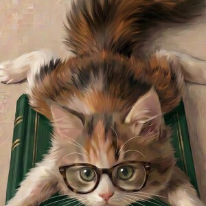 Close-up detail of the calico kitten wearing round glasses, with the green book and cream painterly background visible