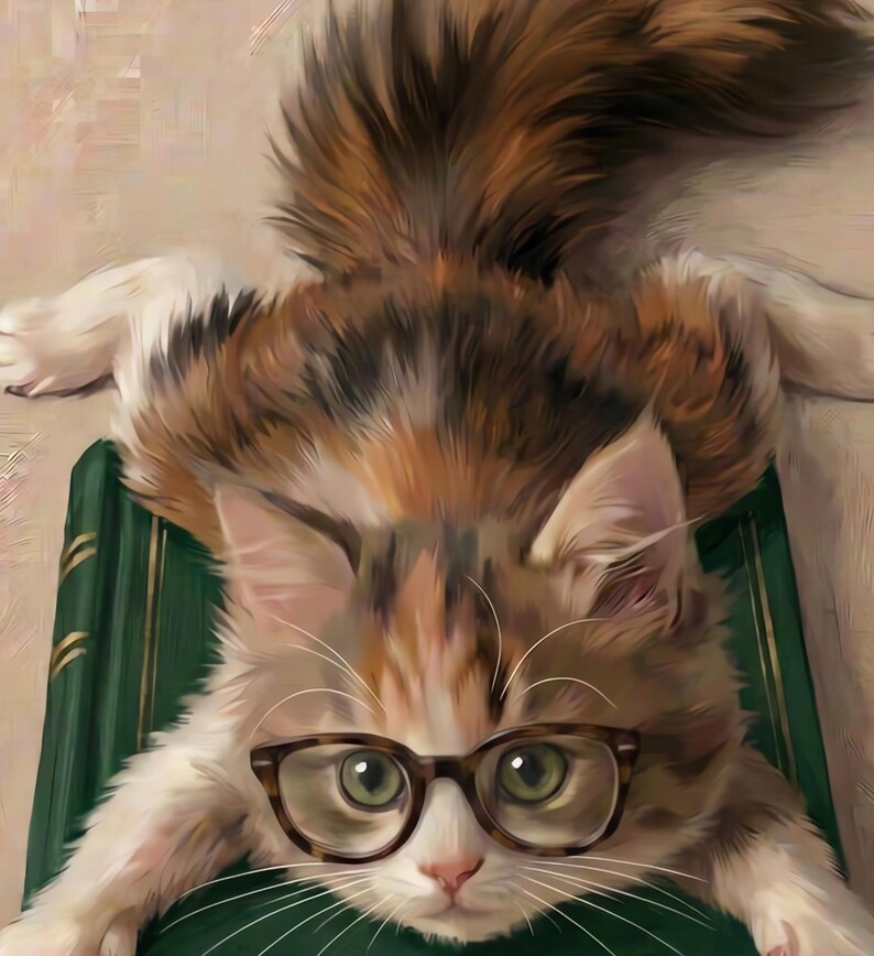 Close-up detail of the calico kitten wearing round glasses, with the green book and cream painterly background visible