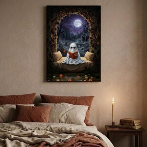 The graveyard arch ghost reading print framed above a bed with linen bedding and a lit candle on the nightstand