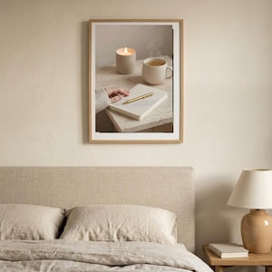 Evening journal ritual wall art printable above linen bed with warm lamplight, neutral beige bedroom decor mockup