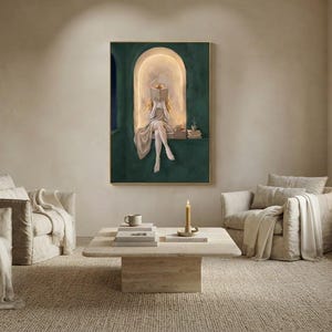 Emerald green reading nook art print above a travertine coffee table in an airy plaster living room, with linen armchairs, a jute rug, a lit taper and a window seat lamp.