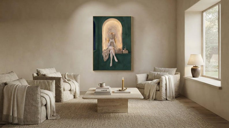 Emerald green reading nook art print above a travertine coffee table in an airy plaster living room, with linen armchairs, a jute rug, a lit taper and a window seat lamp.