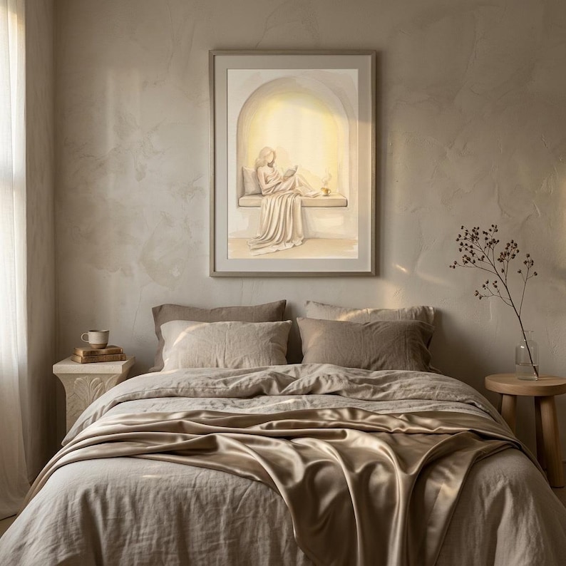 Woman reading nook wall art hung in a quiet bedroom with textured plaster walls, linen bedding, and a thin gold frame, no mat.