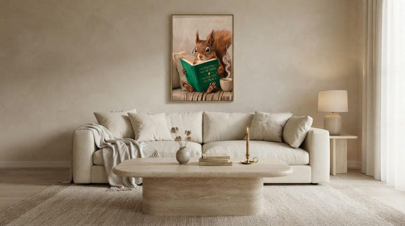 Wide view of a neutral living room with the squirrel reading print framed above a low sofa in soft daylight