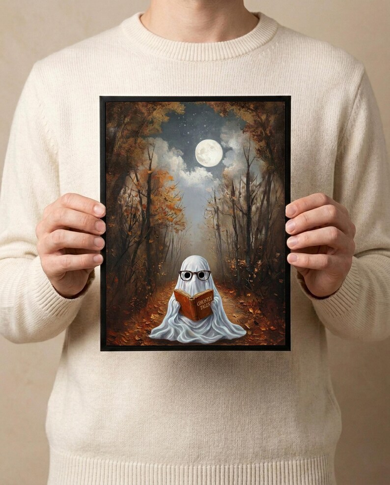 The autumn forest ghost reading print held in both hands by a person in a cream sweater, showing its scale