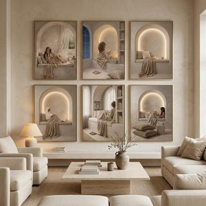 Six gold-framed beige prints on a plaster wall in a neutral living room with two cream sofas, a wide coffee table, stacked books and a stoneware vase.