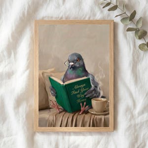 The pigeon reading print in a thin natural oak frame lying on white linen with a sprig of eucalyptus