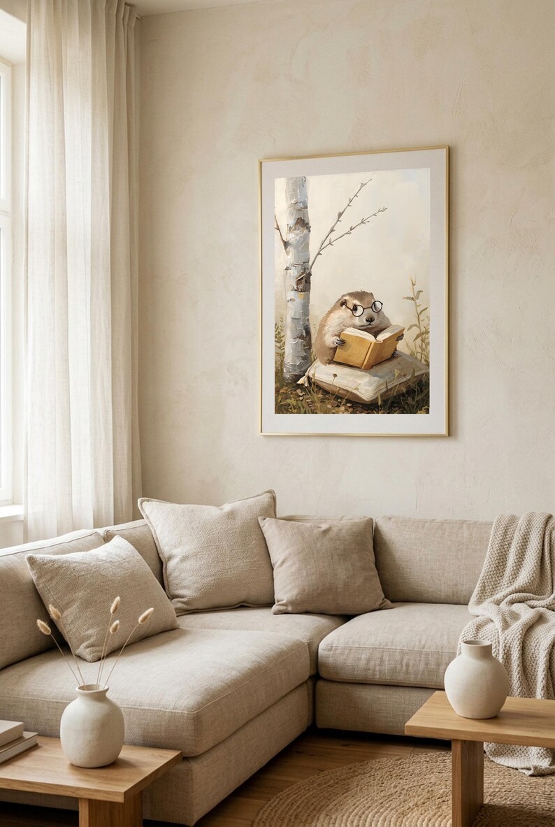 Framed woodland animal print hanging above a cream sectional sofa in a bright neutral living room with linen cushions and a window