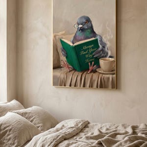 The pigeon print in a thin gold frame hanging above a bed with rumpled linen bedding