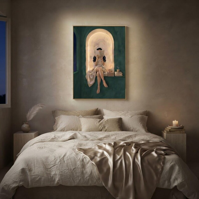 Emerald green reading nook art print glowing above a bed dressed in rumpled linen and champagne silk, on a warm plaster bedroom wall with candlelight and a night window.