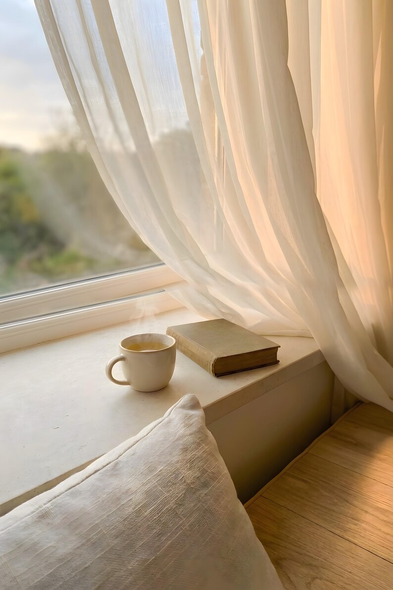 Serene window seat corner wall art with sheer curtains and soft light, open book and coffee on beige ledge, Japandi slow living print, cozy reading nook interior, neutral minimalist home decor, digital printable photography